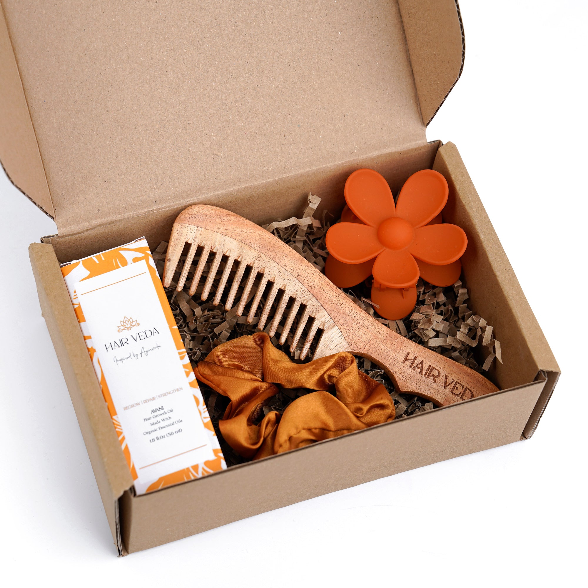 Happy Hair Kit box featuring a comb, hair brush, and orange-hued hair care products inside.