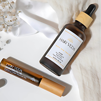 An oil bottle is displayed next to another bottle of oil on a neutral background.